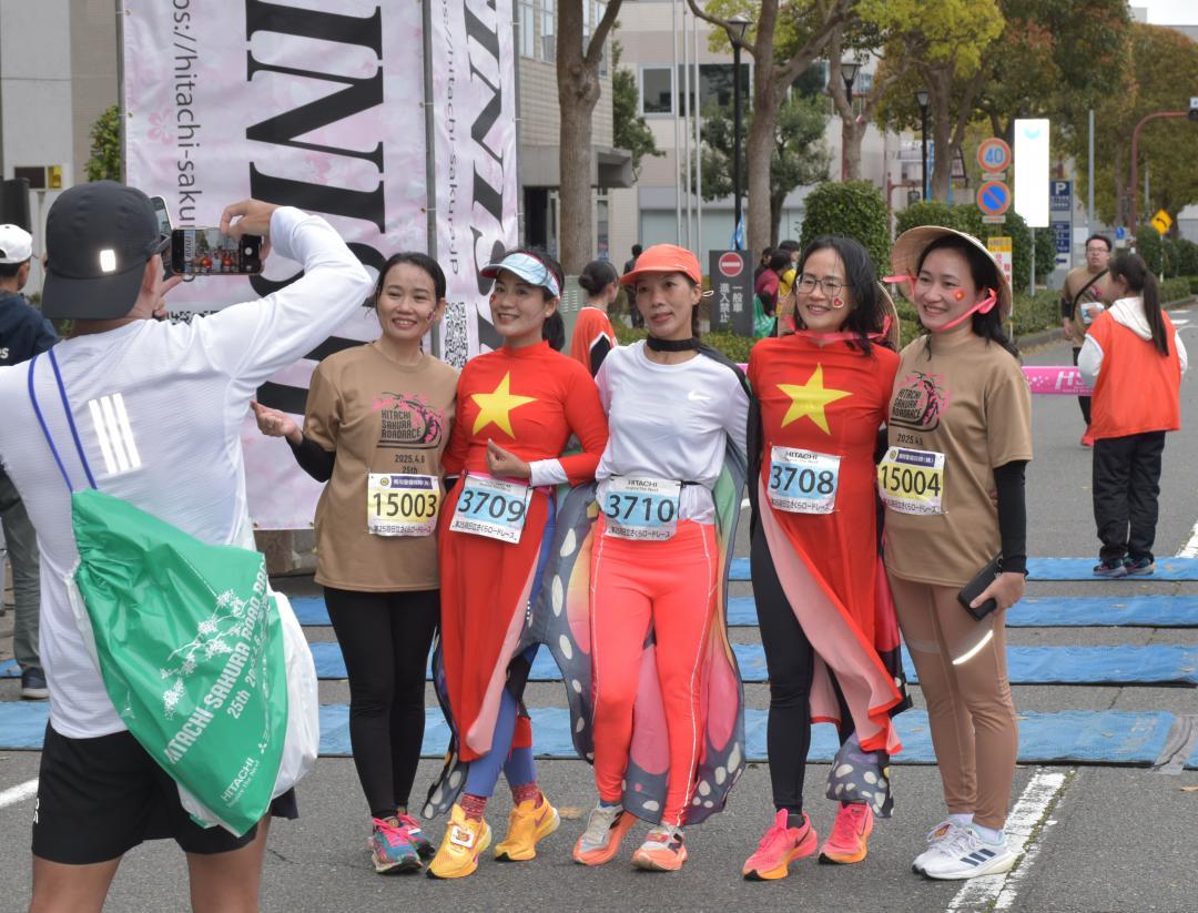 日立さくらロードレースでゴールし記念撮影する外国人ランナー=4月6日、日立市幸町