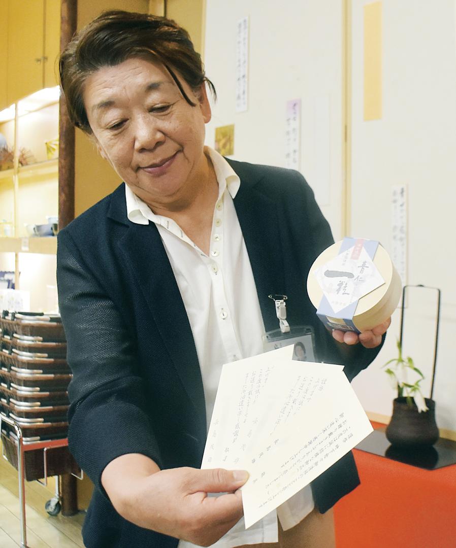長嶋茂雄さんが好物だった納豆「青仁一粒」とお礼のはがきを紹介する「舟納豆」の三次美知子社長=常陸大宮市山方
