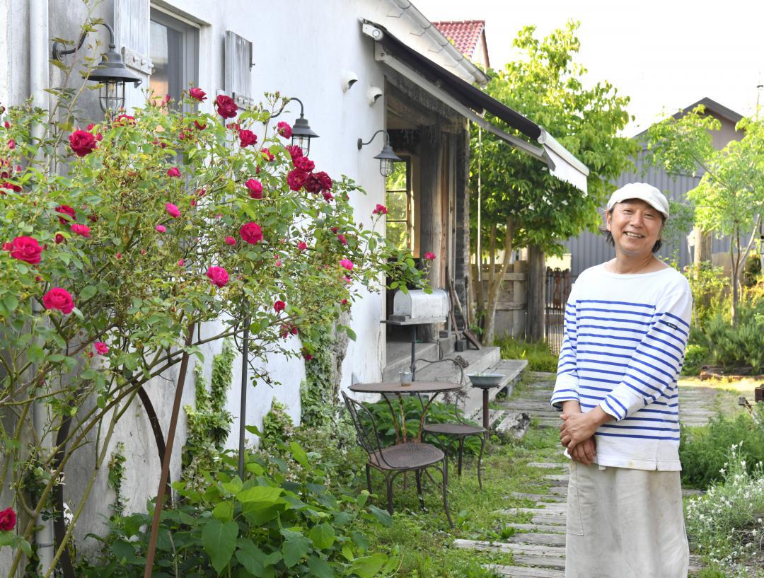 欧州の路地裏を思わせる外観。オーナーの奥沢裕之さんが笑顔を見せる=結城市結城
