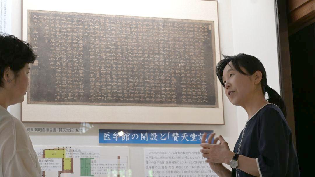 「賛天堂記」の拓本の前で来館者を案内する主任研究員の小圷のり子さん=水戸市三の丸の弘道館