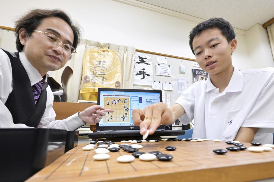 囲碁でAIとの対局を振り返る谷本宏樹さん(右)=水戸市千波町の水戸葵陵高
