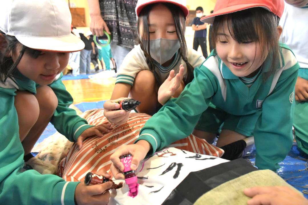 かかしの顔を描く児童たち=北茨城市華川町中妻