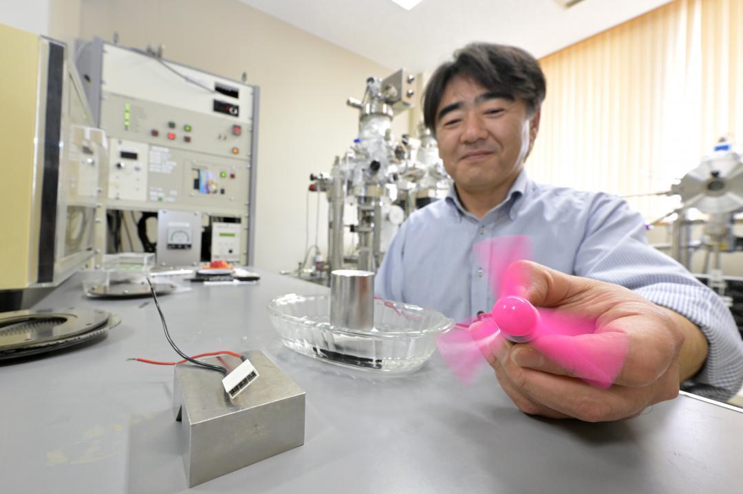 熱電変換素子を使って、温度差で電気が起こる様子を実演する茨城大の小峰啓史准教授=日立市中成沢町