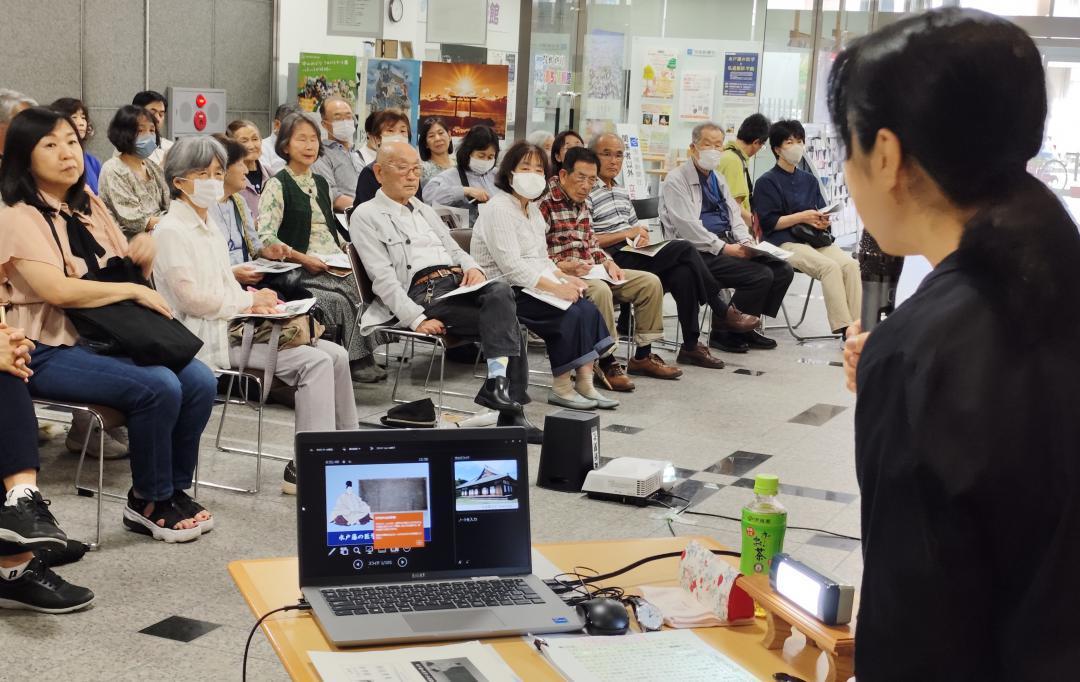 小圷のり子さん(右)の講演に耳を傾ける来館者=水戸市南町
