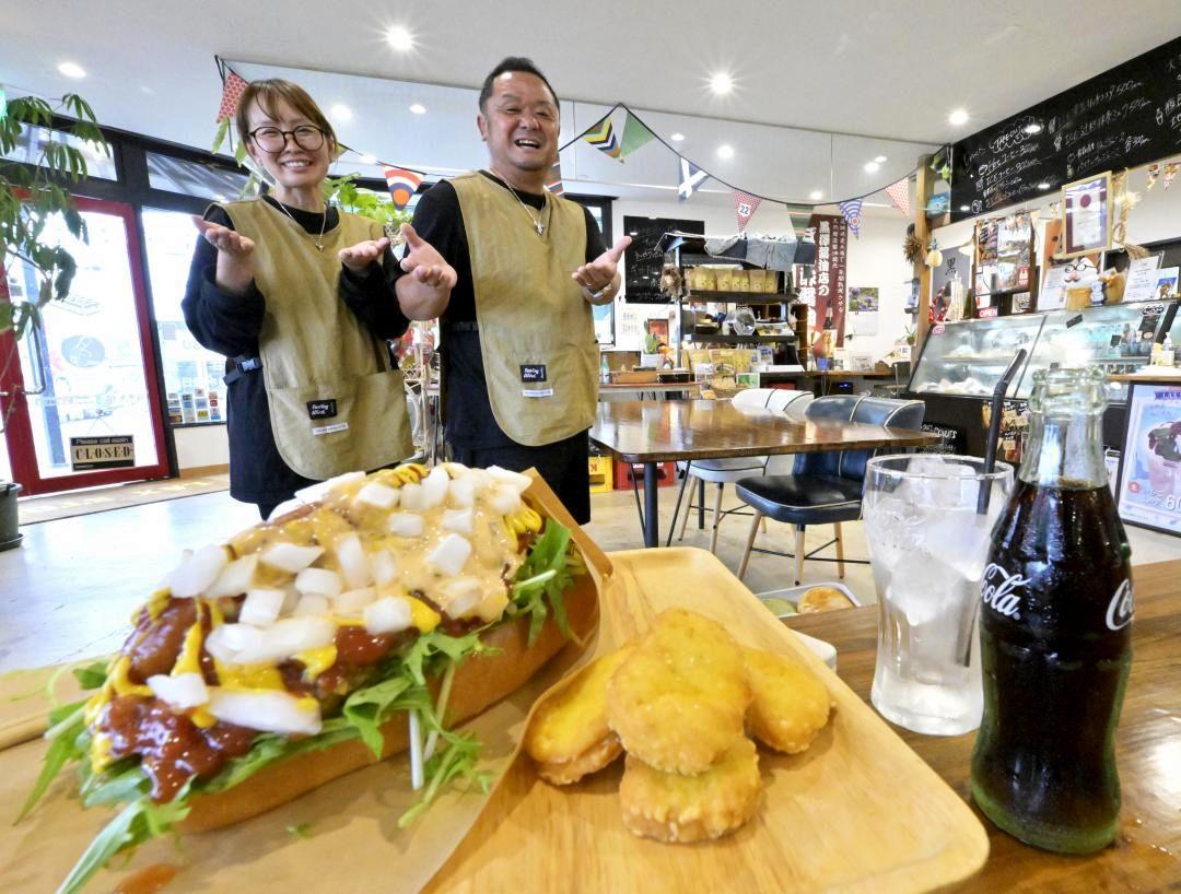 鉾田市産のミズナをたっぷり使った「茨城ドッグ」(手前)。千葉正弘さん(右)らスタッフが笑顔で出迎える=同市勝下
