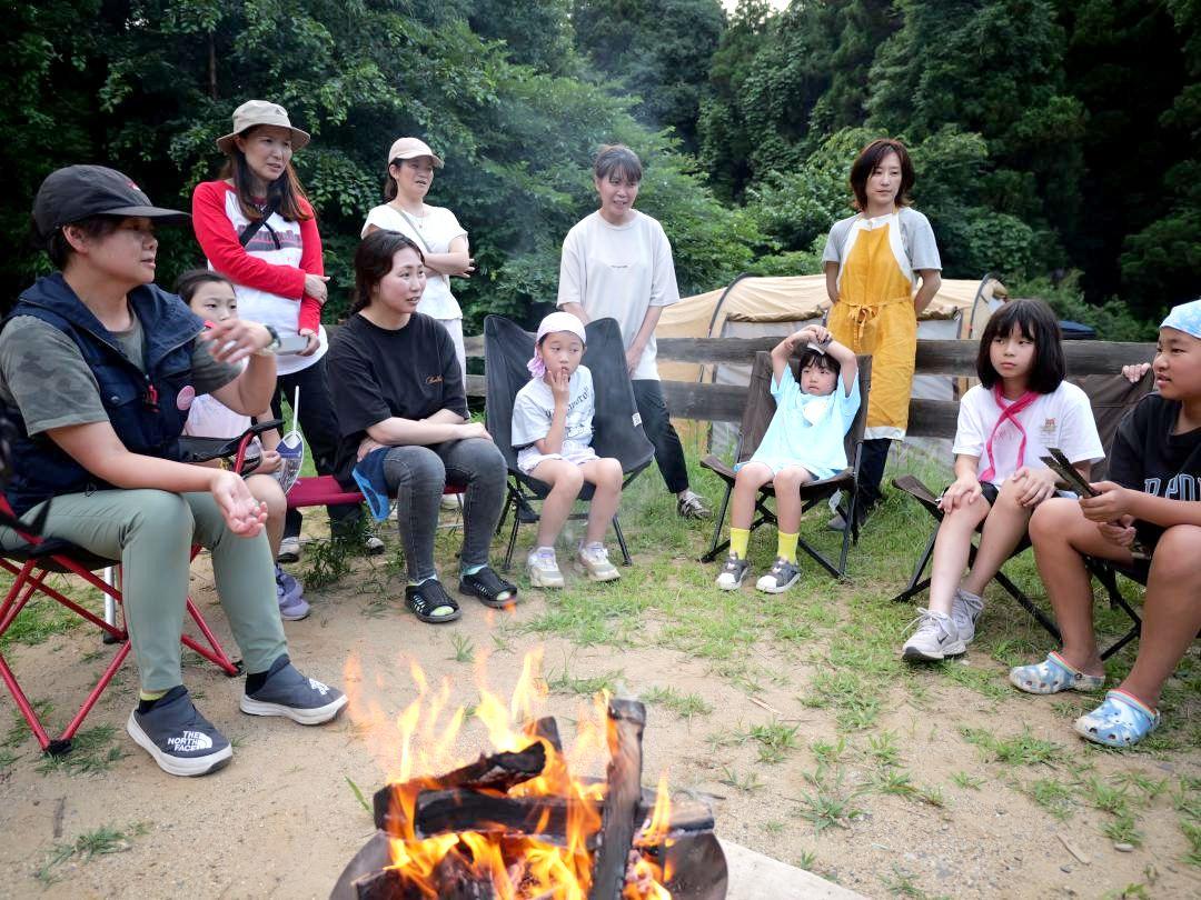たき火を囲みながらアンラッキー後藤さん(左端)の話を聞く参加者=鉾田市安房