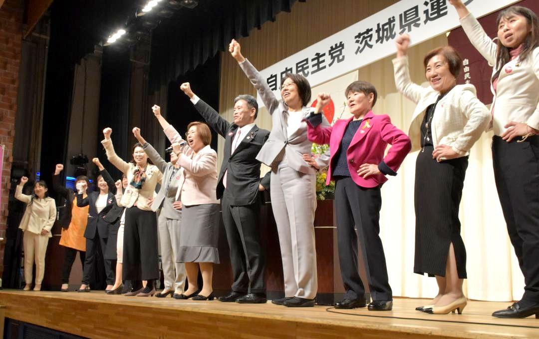 自民党県連女性局大会で上月良祐氏(中央)とともにガンバロー三唱する参加者ら=水戸市千波町