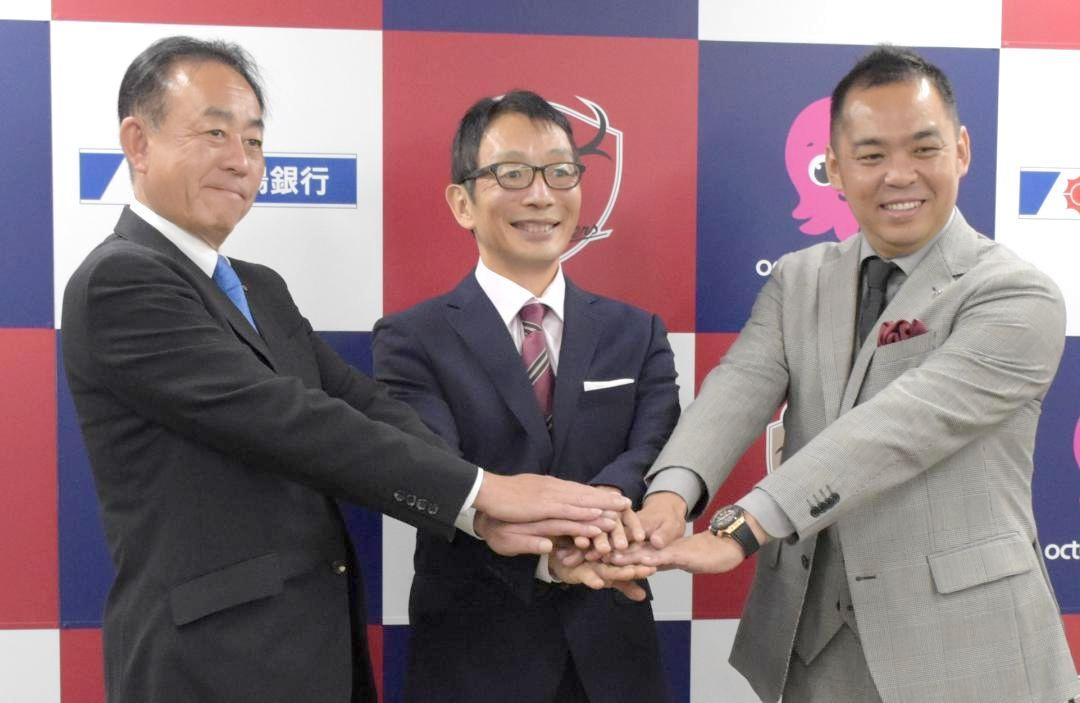 メルカリスタジアムへのグリーンエネルギー供給を発表した(左から)常陽銀行の秋野哲也頭取、TGオクトパスエナジーの中村肇社長、鹿島アントラーズFCの小泉文明社長=鹿嶋市神向寺