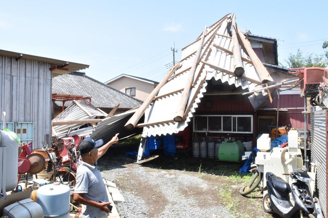 飛ばされて隣家に覆いかぶさった納屋の屋根=2日午前10時半ごろ、かすみがうら市粟田