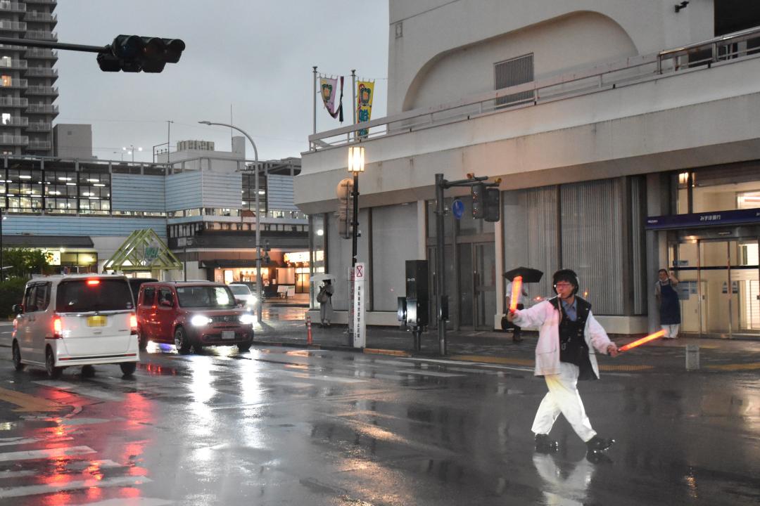 手信号で車や歩行者を誘導する警察官=JR古河駅東口駅前(画像の一部を加工しています)