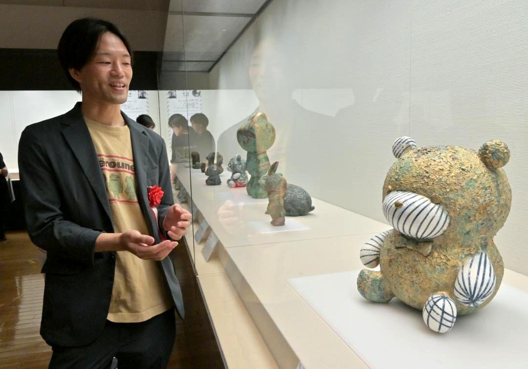 独自の釉薬でさびやコケを表現した自身の作品を紹介する波部圭亮さん=笠間市笠間