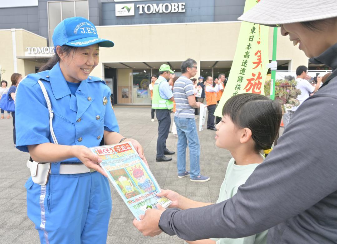 友部サービスエリアの利用者にチラシを配る県警高速隊員=笠間市長兎路