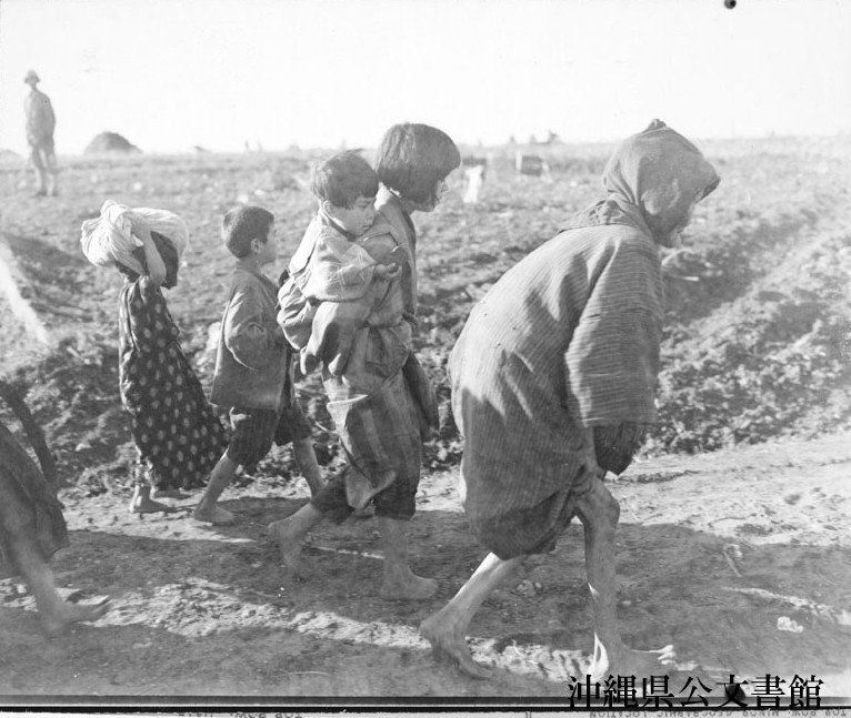 米軍が沖縄戦さなかの1945年4月に撮影した写真。「数週間も隠れていた壕からでてきた人々」とのキャプションが付いている(沖縄県公文書館所蔵)