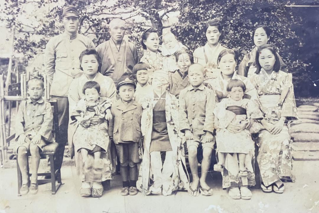 美馬礼子さんの母の実家に残っていた写真。中央に立つ少年の後ろの少女が美馬さん。妹を抱っこする母(前列右から2人目)、兄(前列右から3人目)らが写る。母は弟を妊娠中だった=1944年撮影
