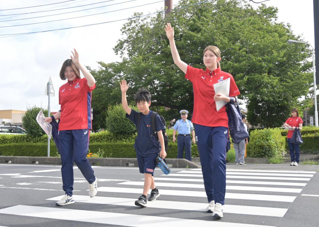 ハンドサインを示して横断歩道を渡るバレーボール選手ら=ひたちなか市東石川
