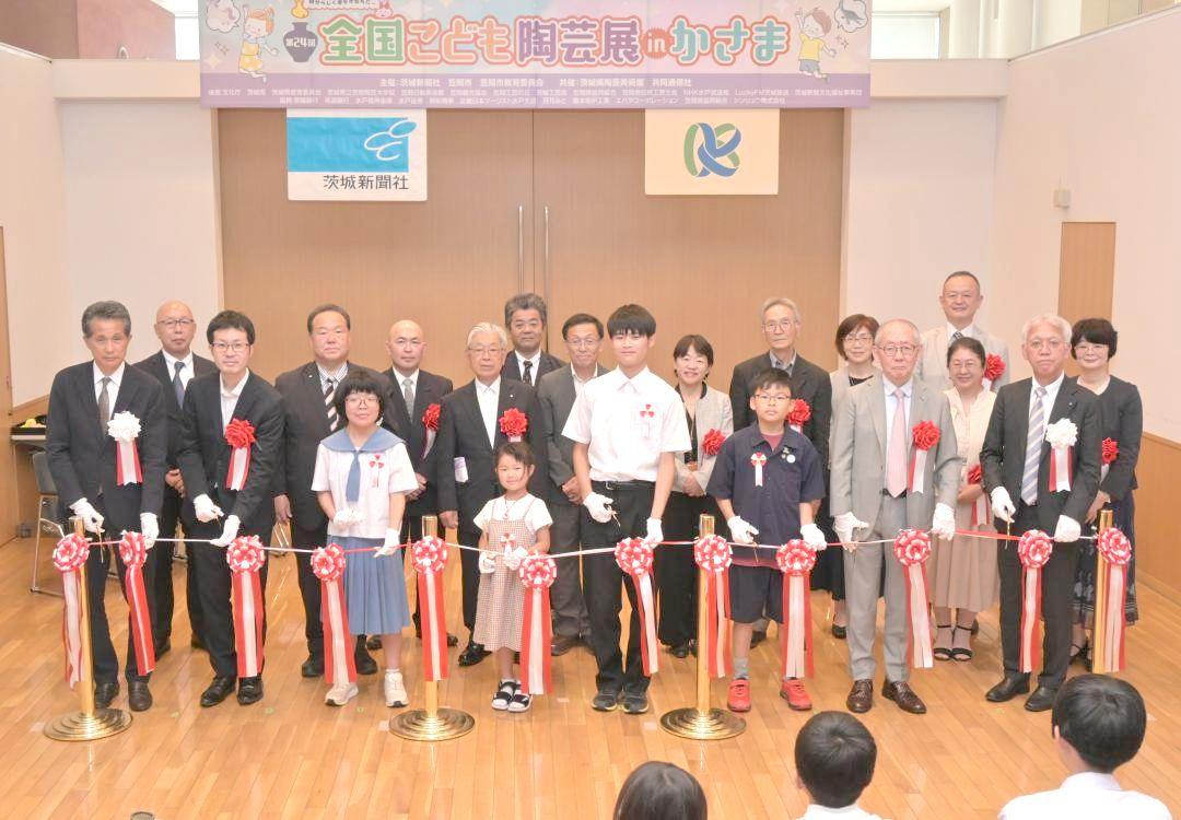 開幕を祝い、テープカットを行う入賞者代表の児童・生徒と関係者ら=笠間市笠間
