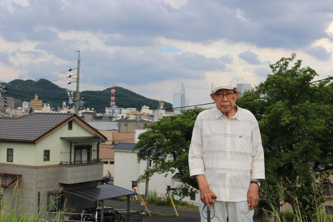 80年前に避難した長良川の堤防で当時の様子を思い返す藤井義一さん=6月25日、岐阜市内
