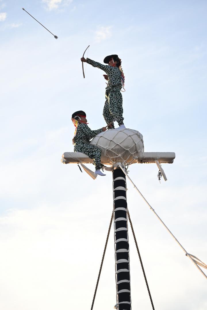 高さ14メートルの柱の上で矢を放つ舞男=龍ケ崎市
