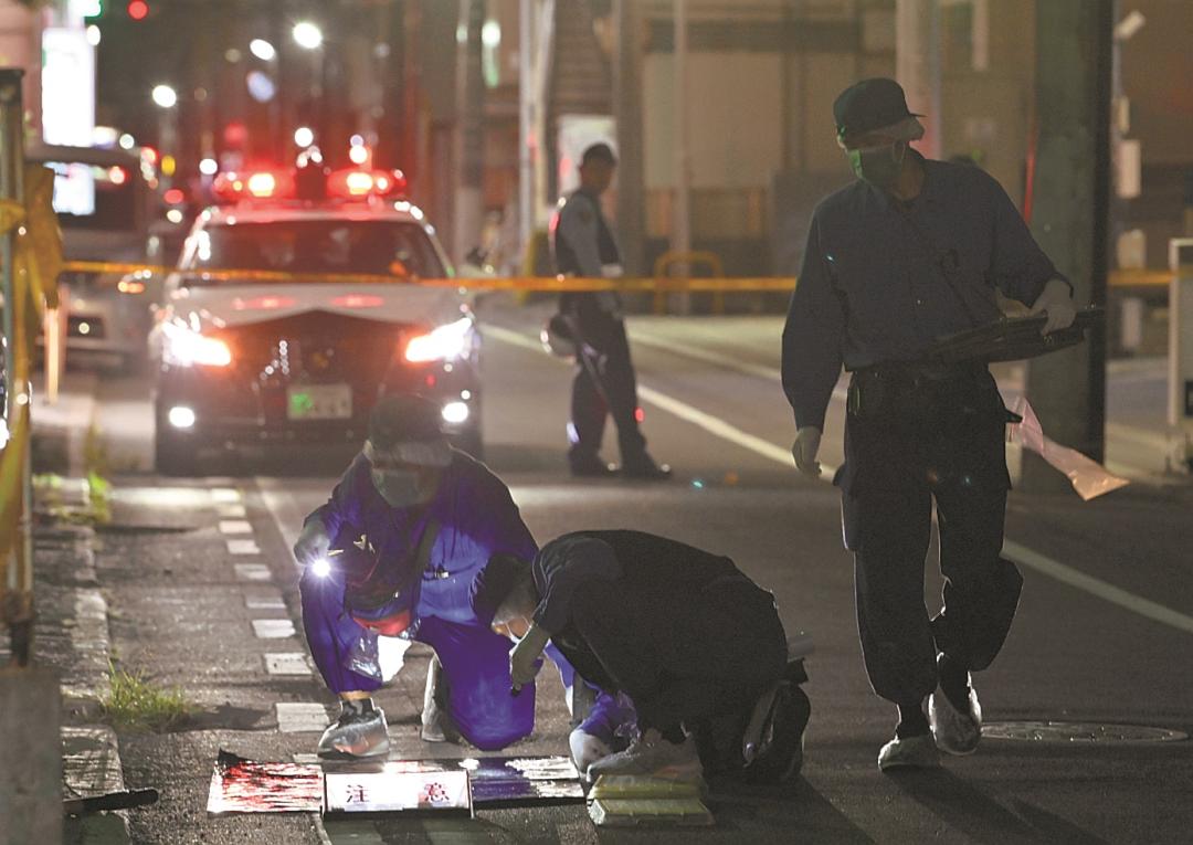 通行人が切りつけられたとみられる現場周辺を調べる捜査員=28日午後8時55分、水戸市南町
