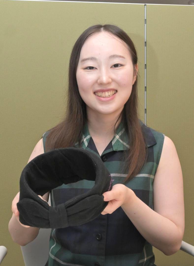 保護帽を手に作品採用の喜びを語った飯島ありささん=水戸市内
