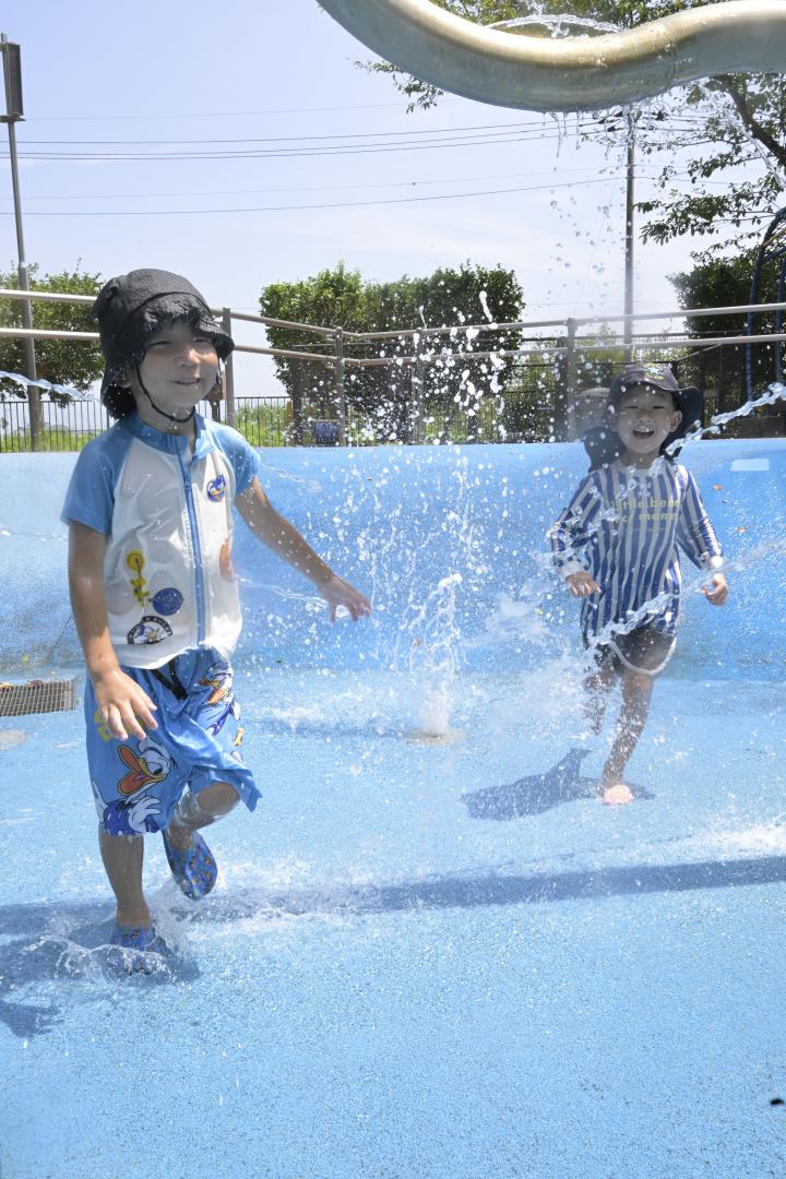 涼しさを求めヒロサワ県西総合公園の「じゃぶじゃぶ池」で遊ぶ子どもたち=5日正午ごろ、筑西市桑山