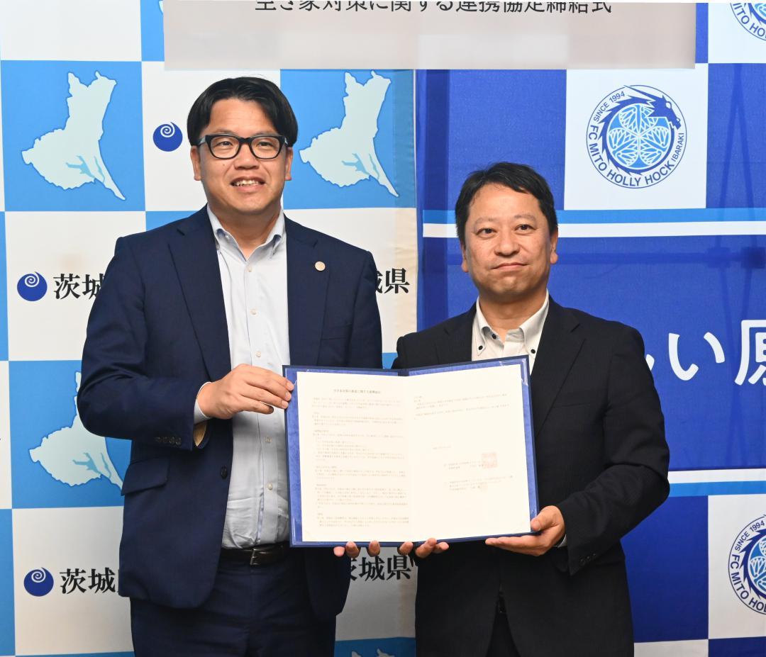 協定書を手にする小島耕社長(左)と岩下泰善副知事=県庁
