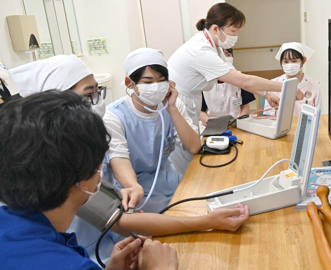 一日看護体験で血圧測定を体験し、看護師の仕事を学ぶ高校生ら=水戸市三の丸の水戸赤十字病院
