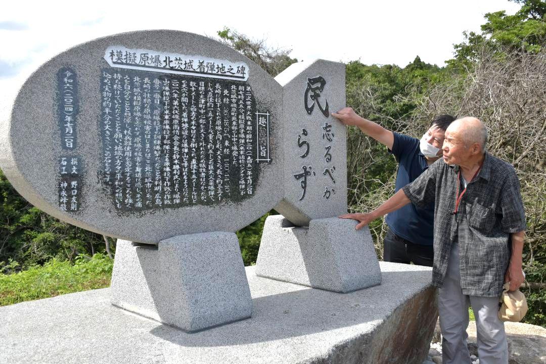 模擬原爆の石碑を建てた野口友則さん(奥)と神永峰敬さん。裏面には投下された地点や犠牲者の人数などが刻まれている=北茨城市磯原町
