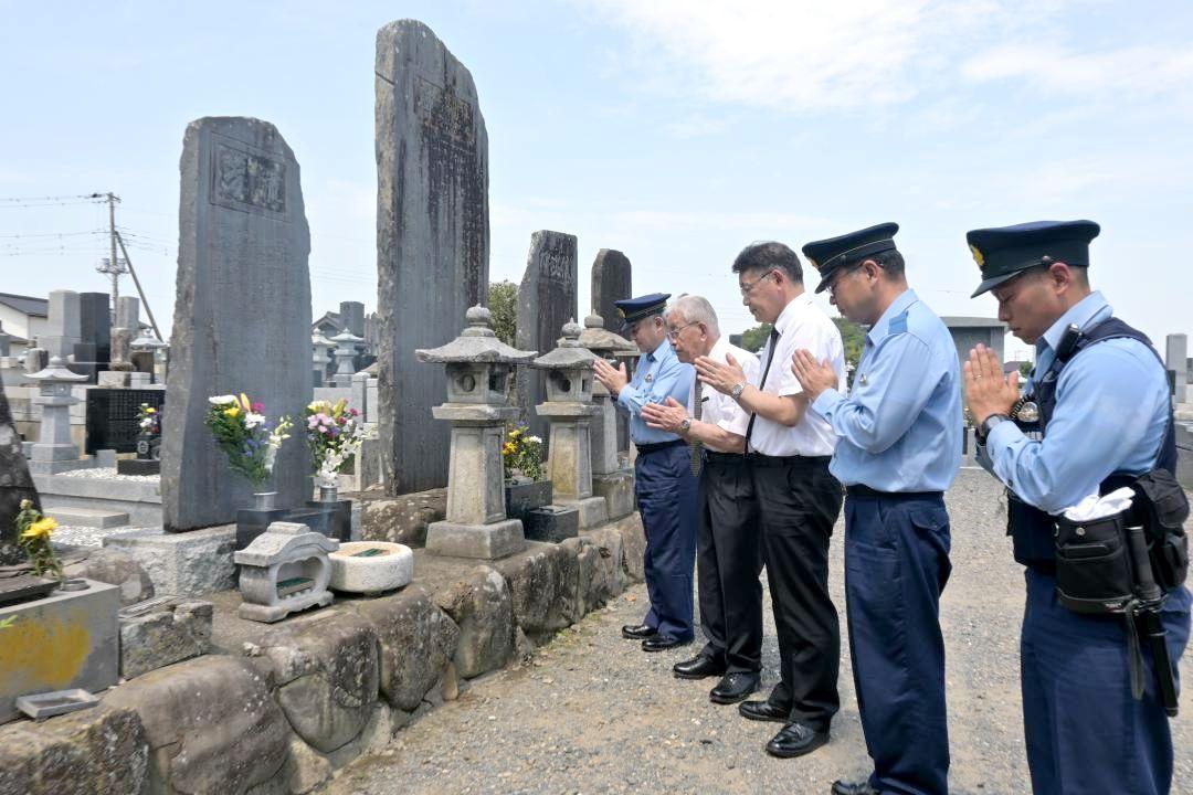 記念碑(左)を前に手を合わせるひたちなか警察署の関係者ら=ひたちなか市平磯町