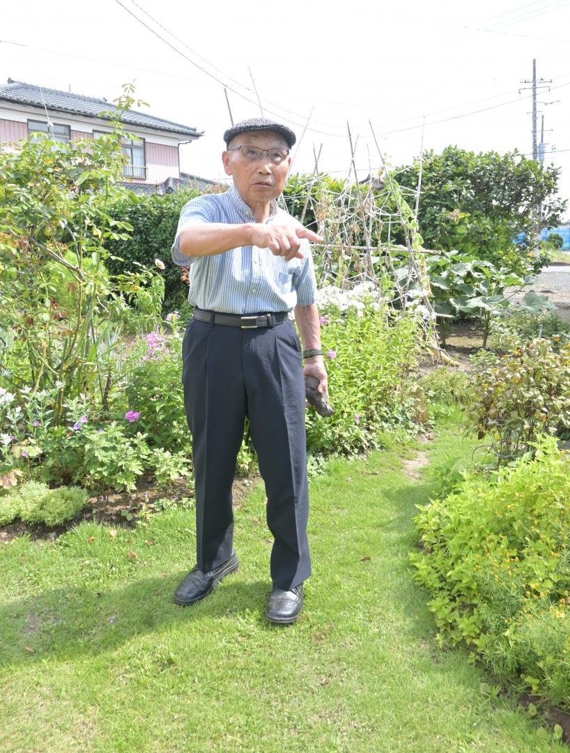 すり鉢状の大きな穴が開いていた畑があった場所を指し示す駒橋一俊さん=水戸市吉沼町
