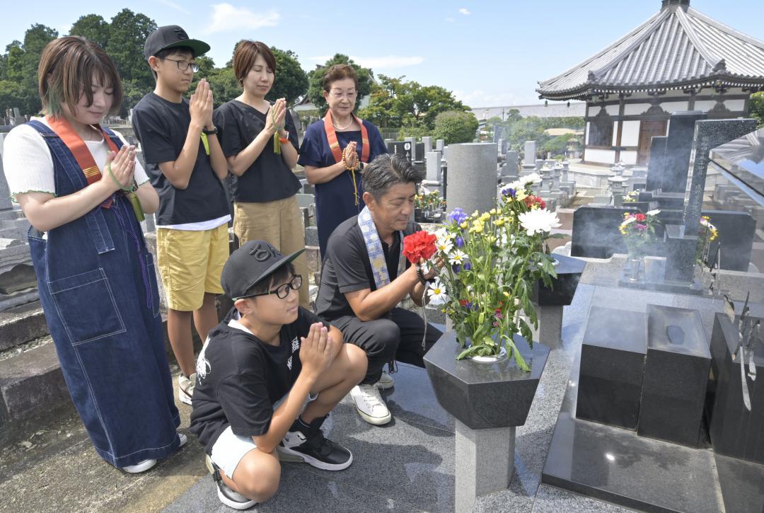 盆の入りを迎え墓参りする家族連れ=13日午後、水戸市酒門町
