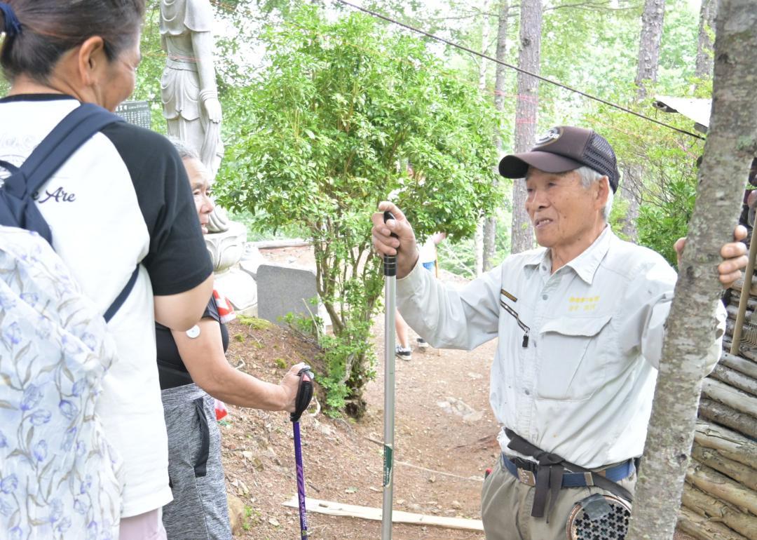 慰霊登山者に声をかける管理人の黒沢完一さん(右)=群馬県上野村
