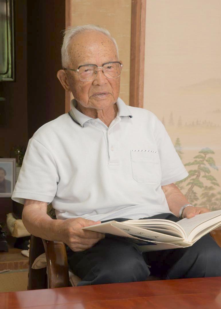 同期生たちが学徒動員の体験をつづった記念誌を手にする仲沢春司さん=潮来市辻