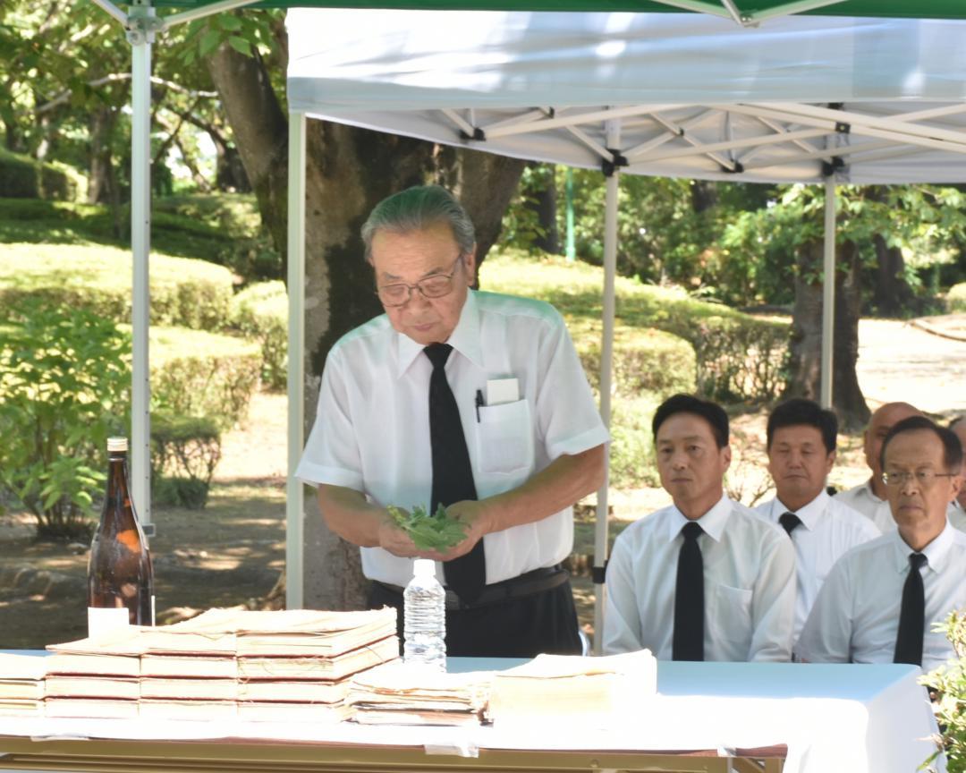 「平和の像　慰霊祭」で献花する坂東市戦没者遺族会長の倉持稔さん(中央)=同市岩井の八坂公園
