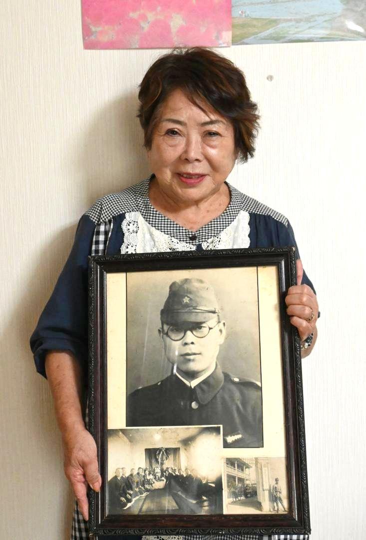 ・父・喜久雄さんの遺影を持つ佐藤弘子さん=東海村内
