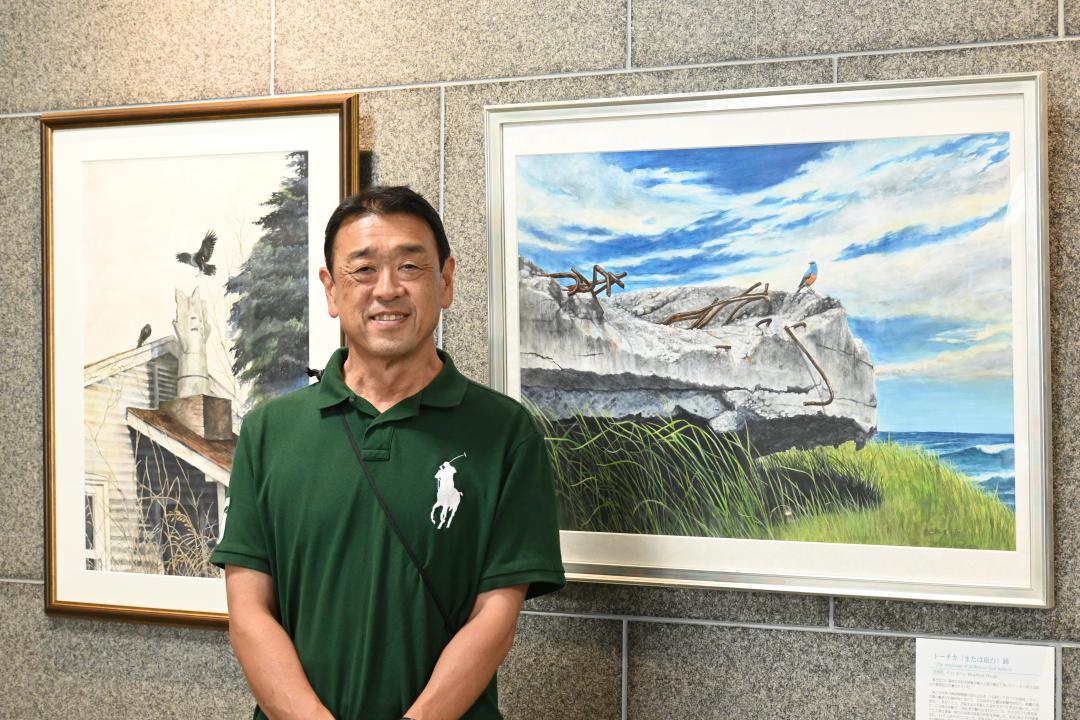 水彩画を展示している栗田健史さん。右は作品「トーチカ(または砲台)跡」、左は「Bоmb Dоdgers Club」=水戸市南町