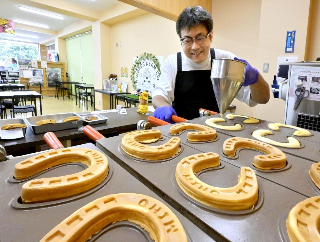 専用の金型を使い「蹄鉄やき」を焼き上げる小川博樹さん=美浦村宮地