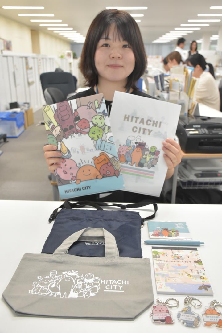 日立市のPRキャラクターグッズを紹介するイラスト担当の田村佳南子さん=同市役所