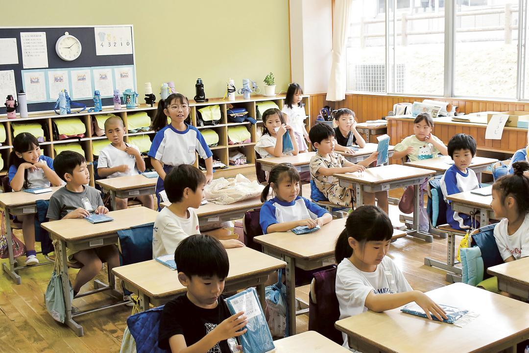 学校が再開して朝の会に臨む1年生。暑さ対策で守谷市から青色の冷感タオルも配布された=同市高野(画像の一部を加工しています)
