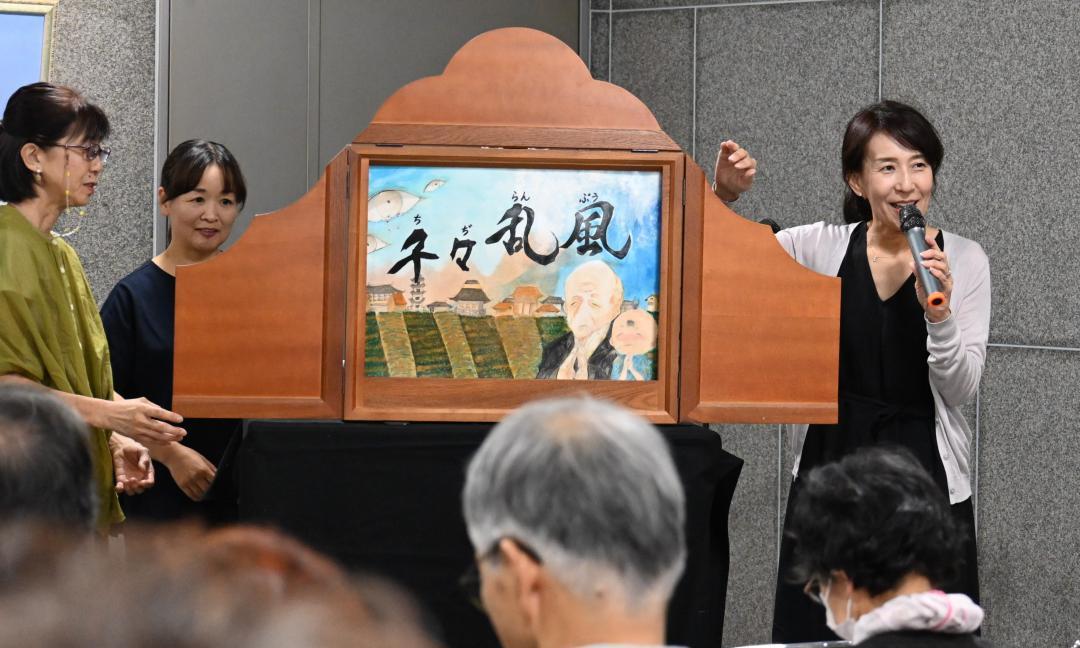 「千々乱風」の大型紙芝居を上演するオリーブ協会のメンバー=水戸市南町
