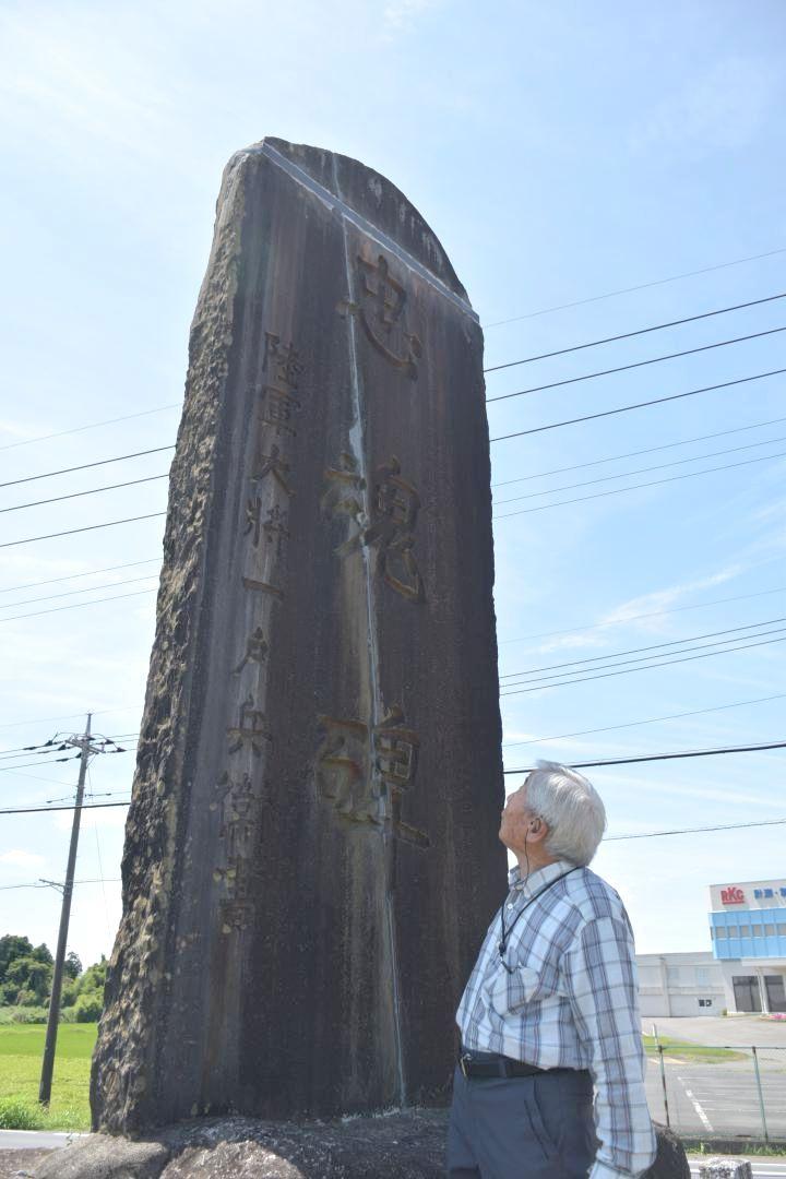 亀裂の跡が残った忠魂碑を見上げる八千代町遺族連合会の斎藤悦雄会長=同町佐野