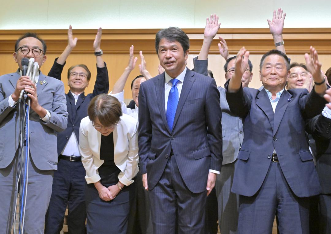 県知事選で3回目の当選が確実となり、感謝の意を示す大井川和彦氏。支持者らの万歳に合わせ、深々と頭を下げた=7日午後8時1分、水戸市内