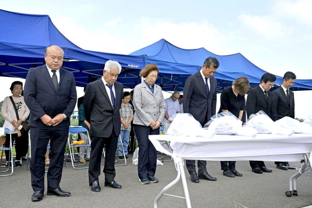 常総水害から10年を迎え、堤防決壊現場で犠牲者を悼み黙とうする神達岳志市長(中央)ら=10日午後0時25分、常総市三坂町
