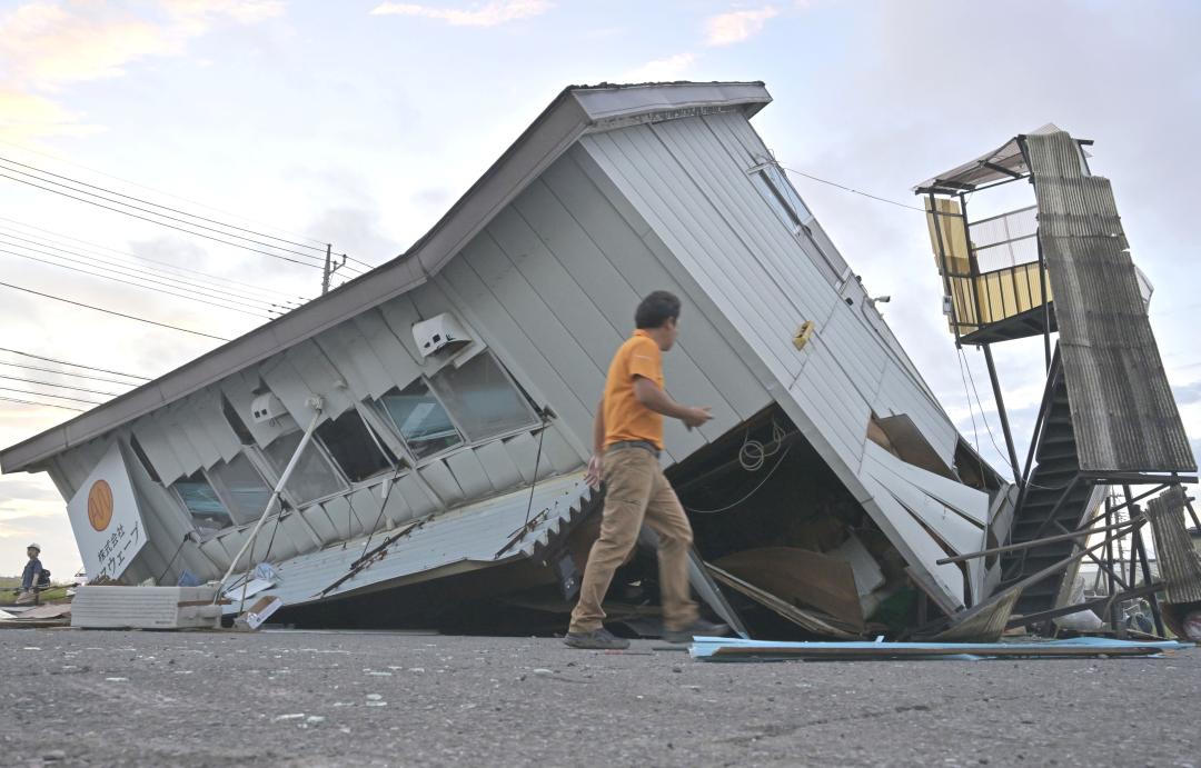 突風の影響で崩れたとみられる建物=18日午後5時40分、つくば市花室