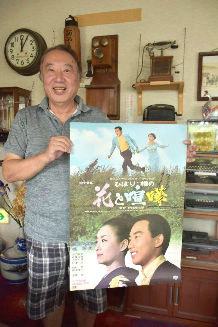 来館の際に橋幸夫さんからサインしてもらった映画ポスターを手にする阿や免旅館の中根猛社長=潮来市潮来