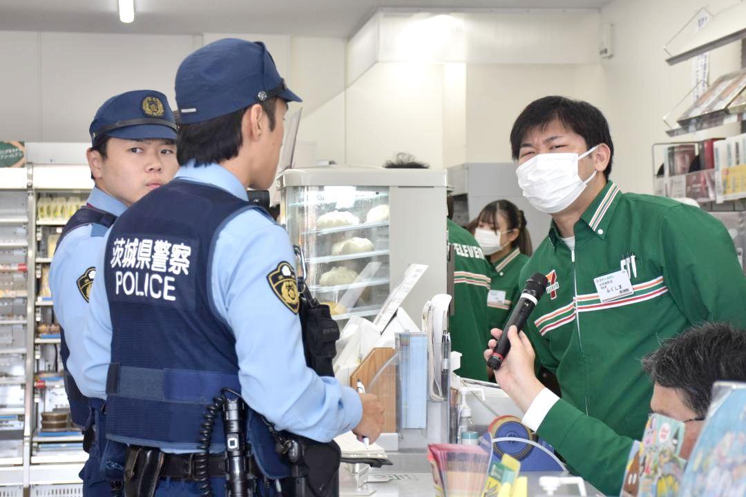 駆け付けた警察官に強盗犯の特徴などを伝える店員=古河市旭町
