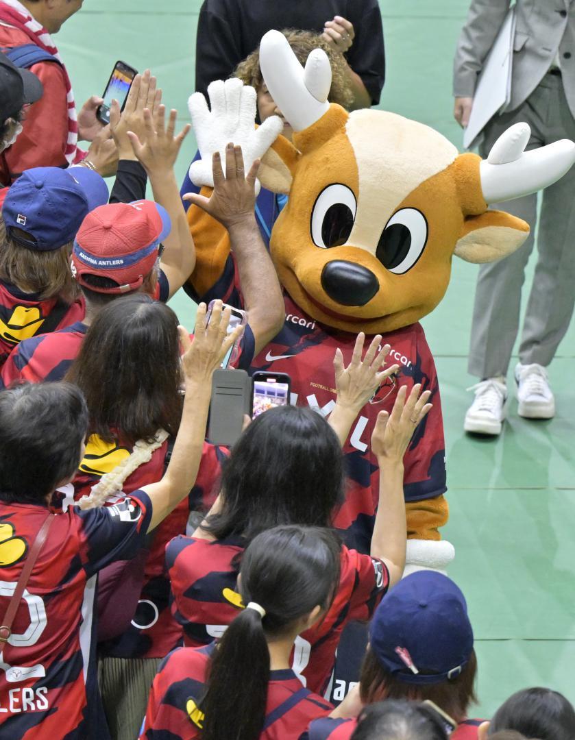 集まったサポーターとハイタッチをするJ1鹿島のマスコット・アントン=鹿嶋市神向寺
