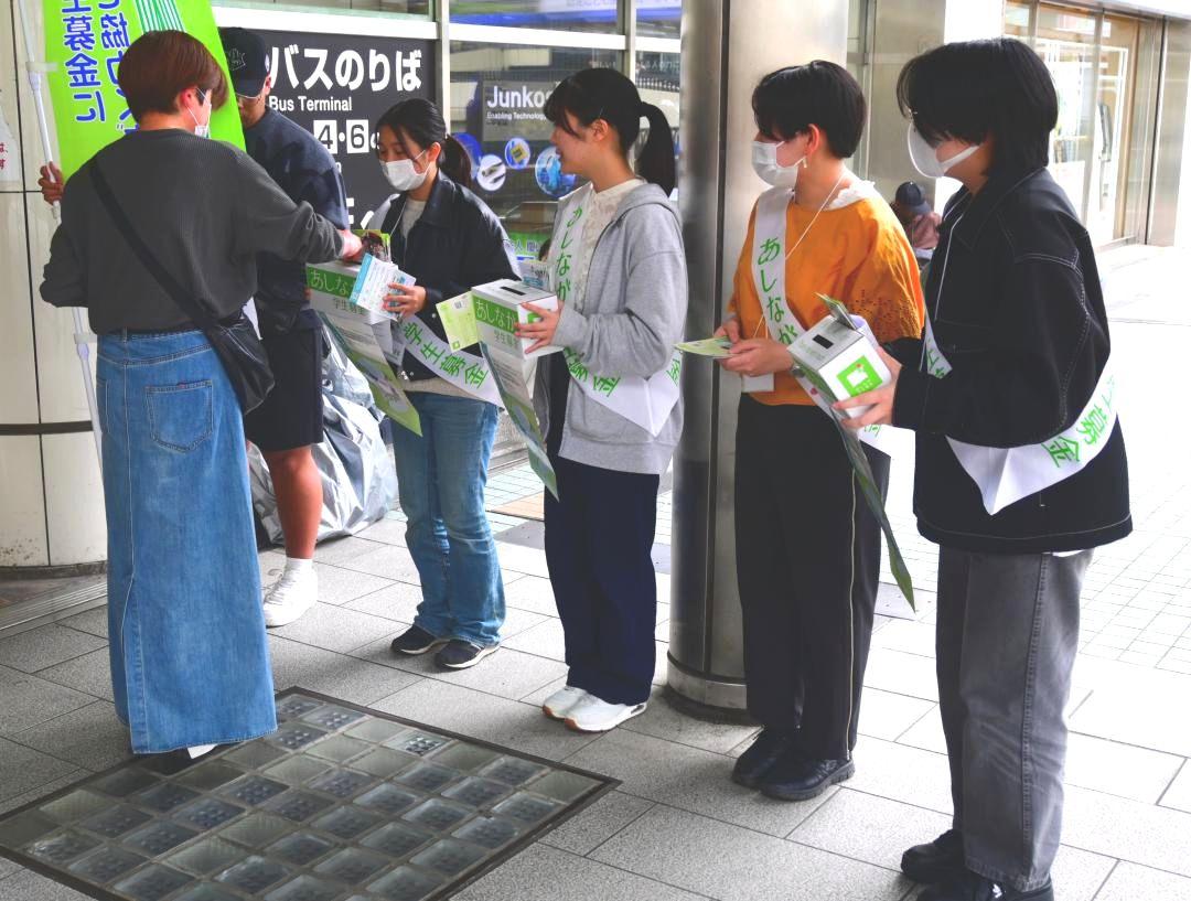 募金箱を手に協力を呼びかける奨学生ら=4月、水戸市宮町のJR水戸駅前