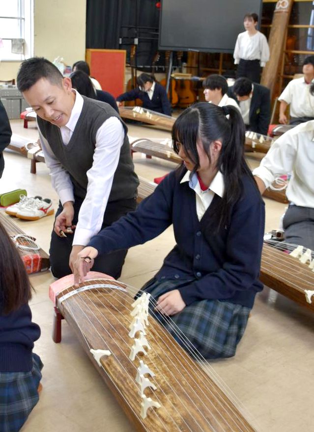 高橋将行さんのアドバイスを受けながら演奏に挑戦する生徒たち=潮来高
