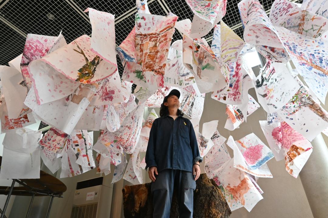 切り株の上に絵をつるして桜の大木に見立てた作品＝取手市小文間